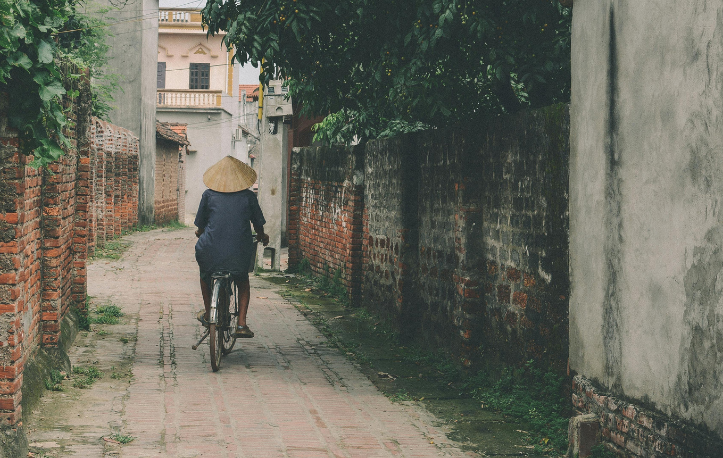 Vietnamese man riding in a bicycle in an alley